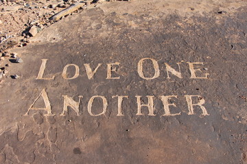 Love One Another carving in sandstone