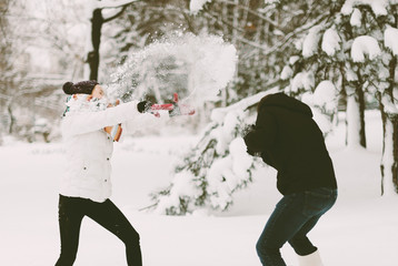 Handsome couple, boy and girl, having fun, throwing in snow