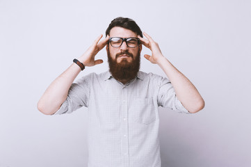 Young unhappy businessman. Bearded man, holds his head, headache and frustrtion.