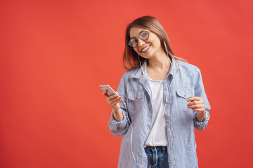 Smiling girl in casual clothes and earphones dancing moving hands.