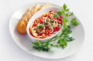 calamari salad with marinated in lemon juice, garlic and olive oil vegetables served with baguette and decorated with parsley