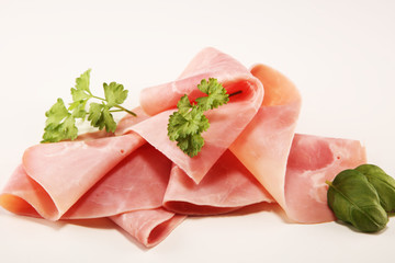 Sliced ham with parsley on table. Fresh prosciutto. Pork ham sliced.