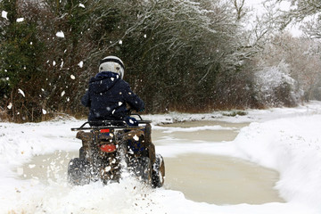 Quad biking on a snow covered countryside farm track