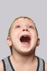 Joyful blond boy in shirt with an open mouth. Isolate on white background.