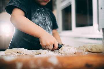 The child makes dough dumplings or dumplings is fun with enthusiasm