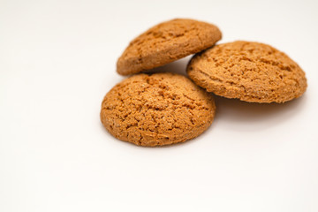 Three homemade oatmeal cookies isolated on white background. Closeup