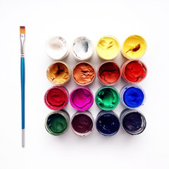 Dry gouache paints and blue brush isolated on white background. Art photography
