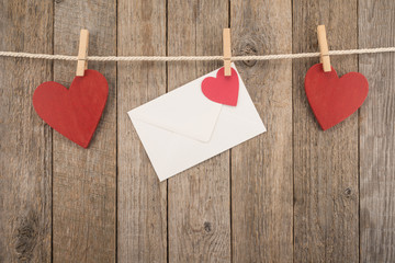 White envelope and red hearts on a rope with pegs
