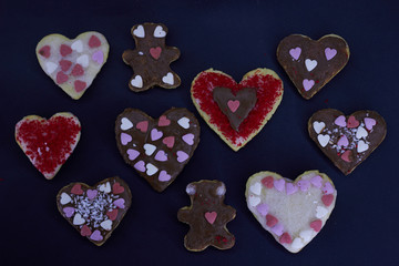 Heart-shaped shortbread cookies decorated for Valentine's Day on a black background. Delicious homemade natural organic pastry with love. Love concept.  