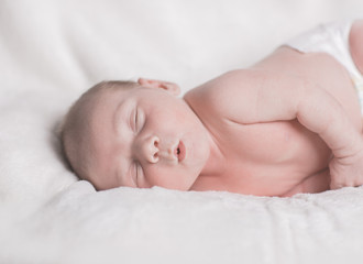 Portrait of a sleeping newborn with funny lips. Concept newborn dreaming.