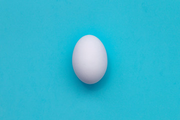 White Easter egg on pastel background. Happy Easter concept. Minimal concept. Flat lay. Top view.