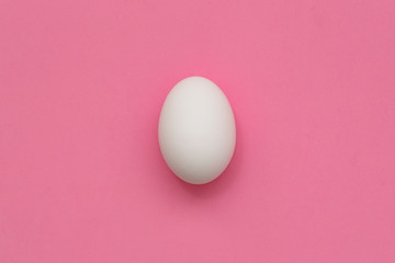 White Easter egg on pastel background. Happy Easter concept. Minimal concept. Flat lay. Top view.