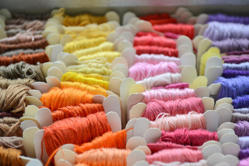 Set of colorful threads in a warm colors for embroidery and sewing closeup