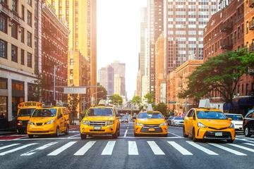 Abwaschbare Fototapete New York TAXI Gelbe Taxis warten auf grünes Licht an der Straßenkreuzung von New York City während des sonnigen Sommertages