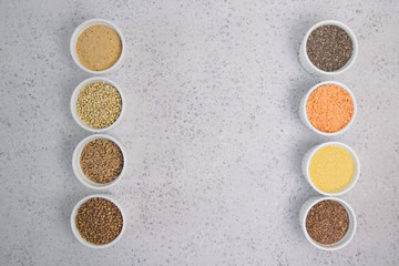 Obraz na płótnie Canvas Collection of different groats on grey background. Top view of buckwheat, chia, flax, amaranth, lentils, couscous, wheat