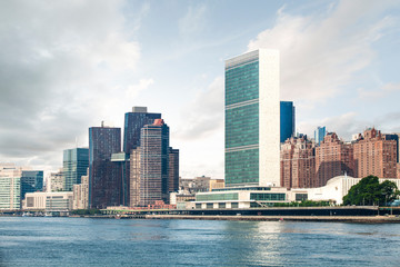View of Midtown Manhattan skyline and the United Nations headquarters, viewed from Roosevelt Island over the East River during sunny summer day