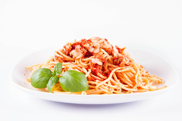 Spaghetti bolognese with melted parmesan cheese decorated with basil on a white background