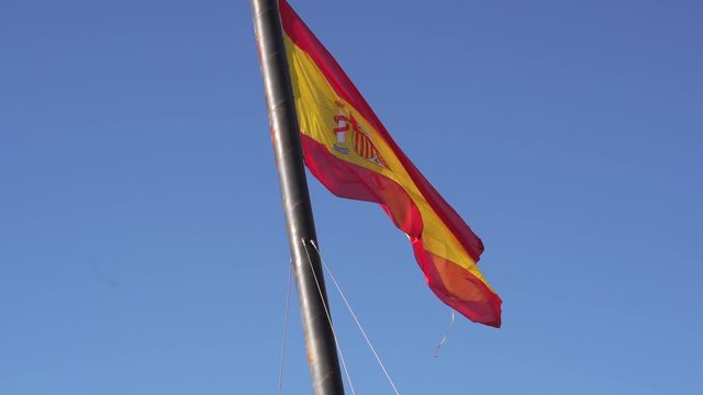 Big Spanish flag waving on the wind. Valencia, Spain. Clear blue skyes on the background. Spanish flag.	