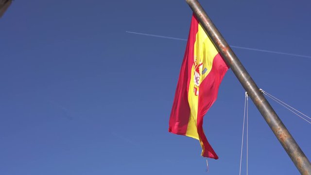 Big Spanish flag waving on the wind. Valencia, Spain. Clear blue skyes on the background. Spanish flag.	