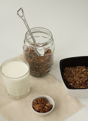 homemade baked muesli and milk on white background, top view, horizontal