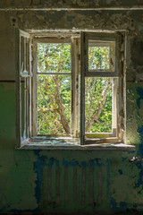 Old abandoned house with windows. Colorful cement stone wall. Cracked wall with old layers of paint in abandoned house