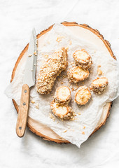 Healthy snack, breakfast - peanut butter, seeds, nuts banana  bites on wooden board on a light background, top view. Copy space