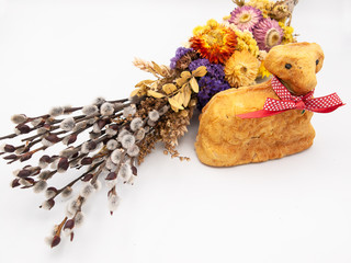 Traditional religious Easter willow branches decorated with dried flowers and a backed Easter bread in a form of a lamb isolated on a white background