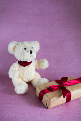 toy white, polar bear, gift box on pink background (vertically)