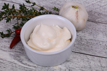 Mayonnaise sauce in the white bowl served thyme and garlic