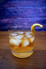 Old Fashioned cocktail with ice and lemon rind