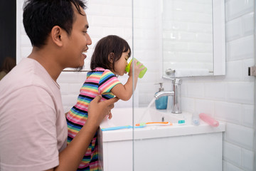 little girl gargle after brush her teeth