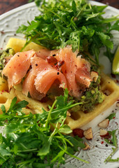 Potato waffles with avocado guacamole and smoked salmon for breakfast