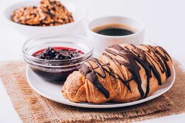 Breakfast with coffee, milk and croissants on wooden table