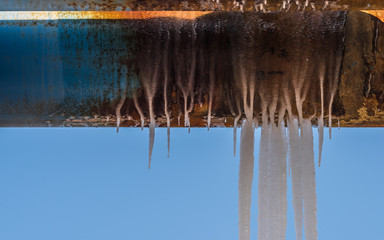 An icicle on a blue water pipe