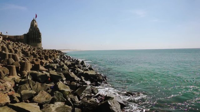 Panning shot of breakwater, lighthouse, temples near dwarka beach Gujarat india