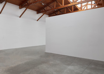 An empty room art gallery with wood ceiling and concrete flooring