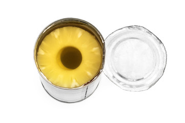 Opened metal tin can with canned pineapple rings on white.