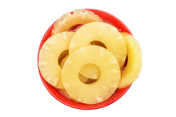 Bowl with canned pineapple rings on white. Top view.
