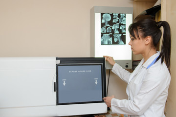 Young radiologist doctor, scanna x ray cassette in x ray room