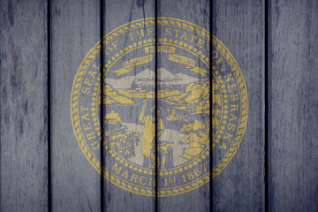 USA Politics News Concept: US State Nebraska Flag Wooden Fence