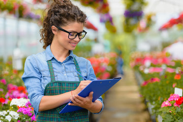 Young woman entrepreneur working in flower garden