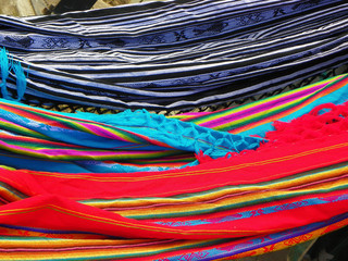 Close-up of colorful  hammocks made from natural fabric hanging in street market in Ecuador. Pattern background