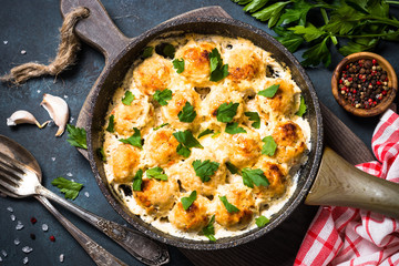 Meatballs in cream sauce on dark stone table top view.