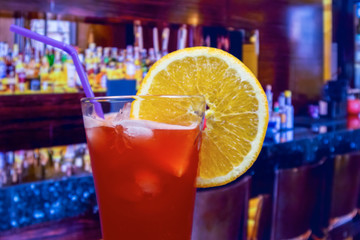 Plantation punch cocktail in hurricane glass with straw and orange slice