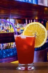 Plantation punch cocktail in hurricane glass with straw and orange slice