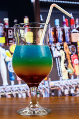 Rainbow cocktail in sour glass with straw