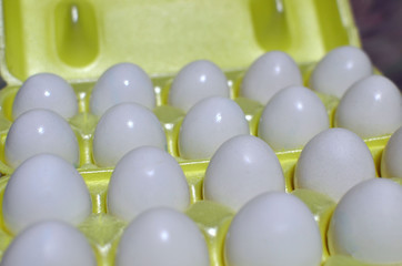White chicken eggs in a cardboard package, background, texture