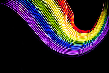 Abstract lines made with light painting with the colors of the rainbow on black background