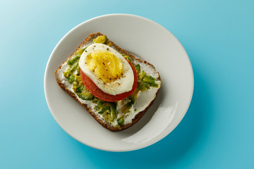 sandwich with avocado salad on white plate blue background Avocado and mayonnaise with egg and paprika.