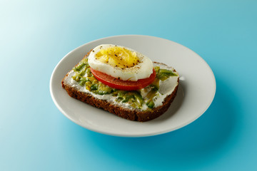 sandwich with avocado salad on white plate blue background Avocado and mayonnaise with egg and paprika.